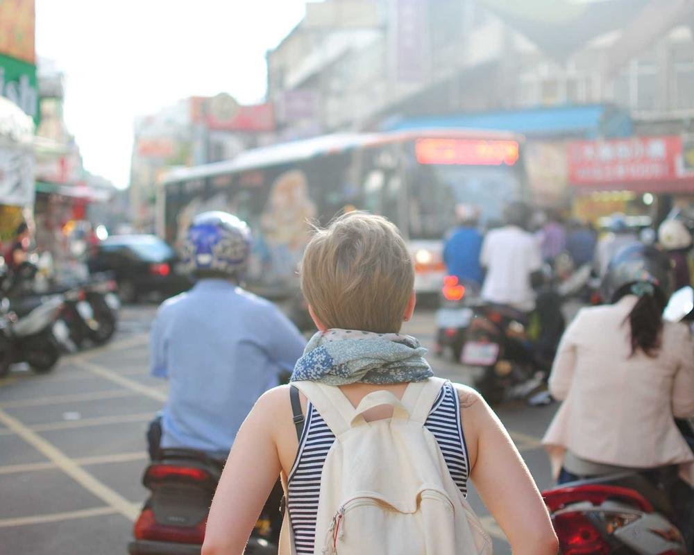 Traveler walking through a busy street, representing travel insurance coverage from Khueman Insurance
